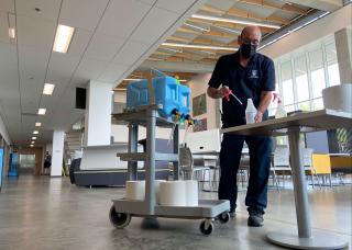 UBCO staff keeping the self-serve sanitation stations stocked with supplies