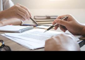 Two hands using pens